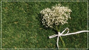 Zrównoważony rozwój branży pogrzebowej. Zielona trawa na której leży naturalny bukiet kwiatów.